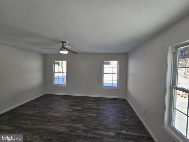 unfurnished room featuring dark wood-style floors, baseboards, and a ceiling fan