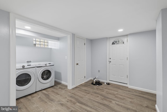 laundry room featuring washer and clothes dryer and light hardwood / wood-style flooring