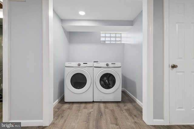 clothes washing area with light hardwood / wood-style floors and independent washer and dryer