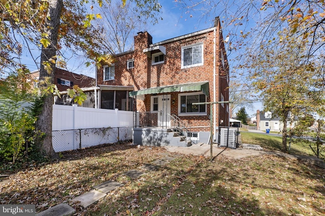 rear view of house featuring a sunroom and central air condition unit