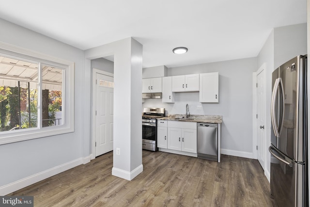 kitchen with white cabinets, appliances with stainless steel finishes, dark hardwood / wood-style floors, and sink