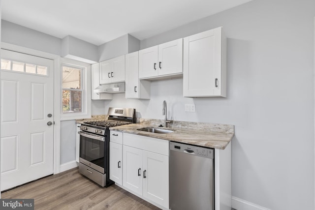 kitchen with sink, stainless steel appliances, light hardwood / wood-style flooring, white cabinets, and exhaust hood