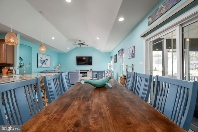 dining space featuring ceiling fan, lofted ceiling, and sink