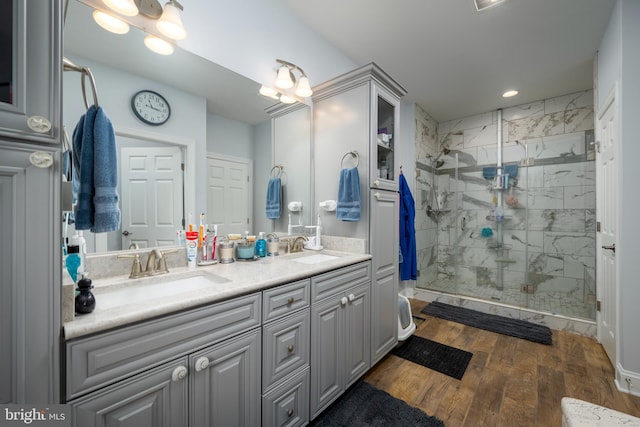 bathroom with hardwood / wood-style flooring, vanity, and a shower with door