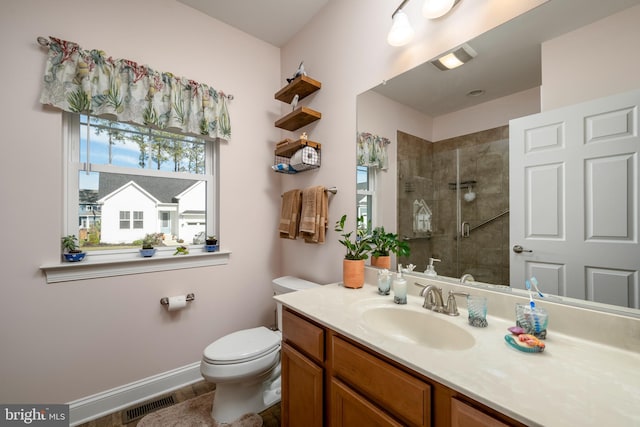 bathroom featuring vanity, toilet, and a shower with door