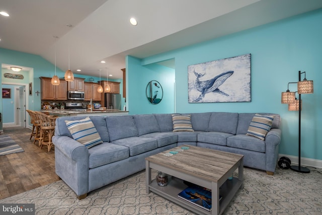 living room featuring light wood-type flooring and vaulted ceiling