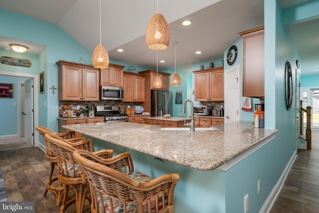 kitchen with decorative backsplash, pendant lighting, stainless steel appliances, and lofted ceiling