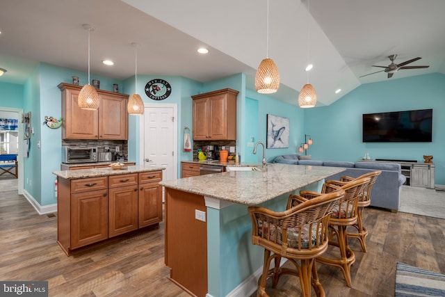 kitchen featuring a kitchen breakfast bar, kitchen peninsula, decorative backsplash, and pendant lighting