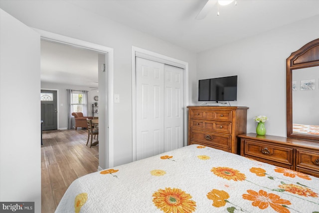 bedroom featuring light wood-type flooring, a closet, and ceiling fan