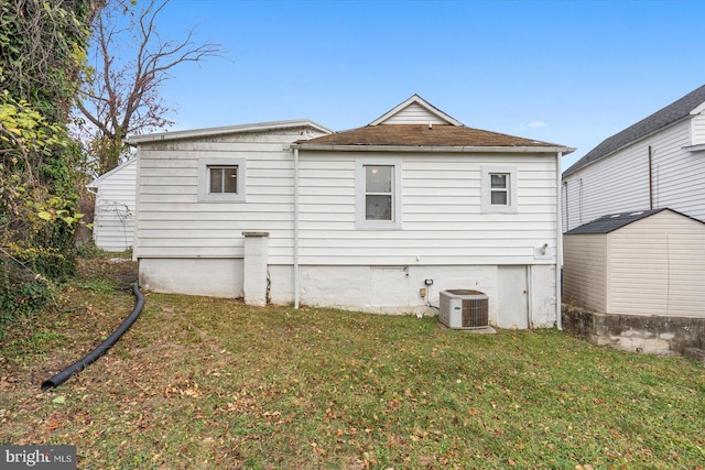 rear view of house with a yard, a shed, and cooling unit