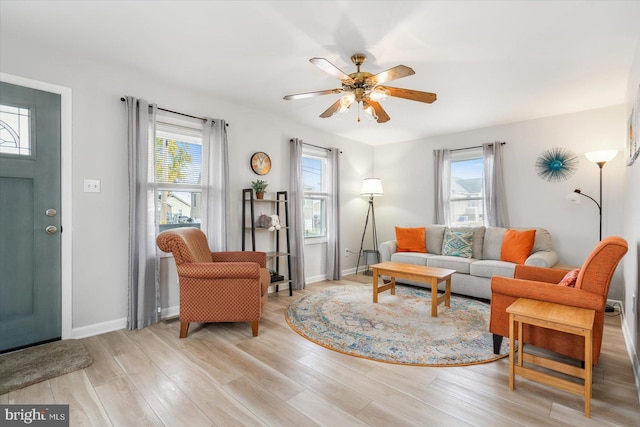 living room with light hardwood / wood-style floors and ceiling fan