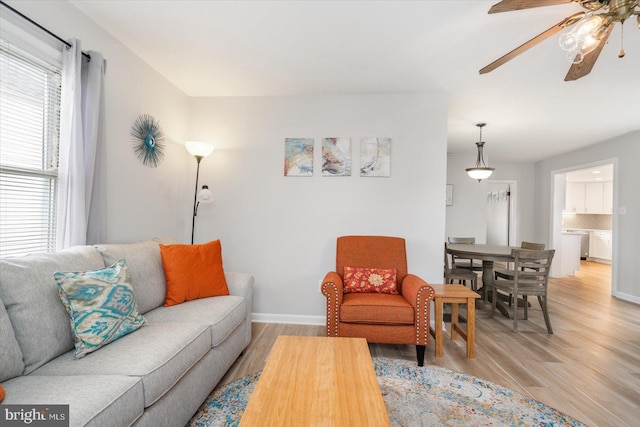 living room featuring ceiling fan and light hardwood / wood-style flooring