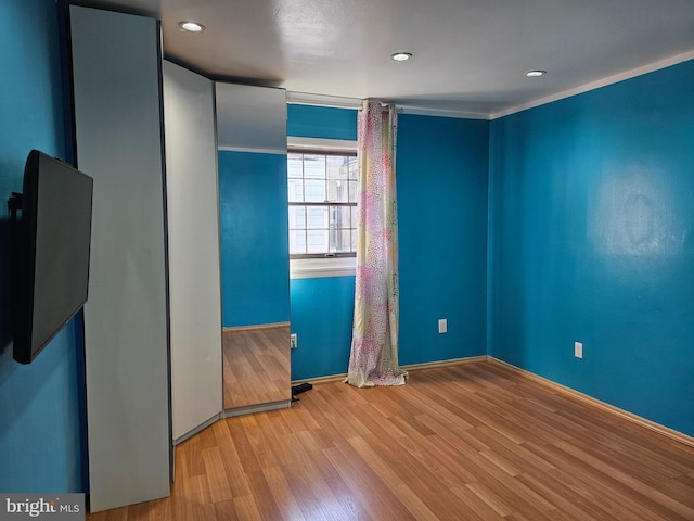 spare room featuring ornamental molding and light hardwood / wood-style flooring