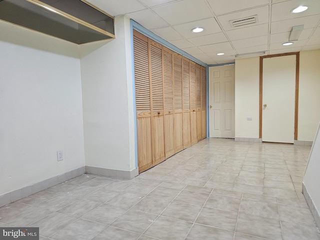 interior space featuring a drop ceiling and light tile patterned floors