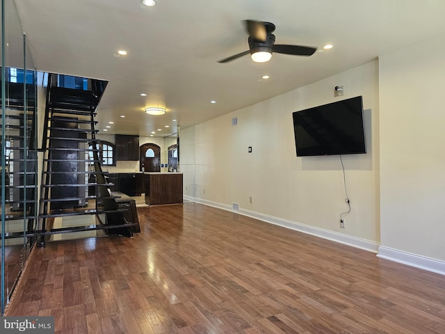 living room with ceiling fan and dark wood-type flooring