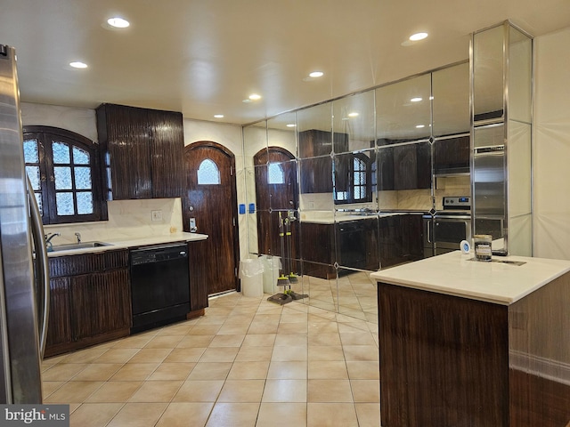 kitchen featuring tasteful backsplash, dark brown cabinets, stainless steel appliances, sink, and light tile patterned floors