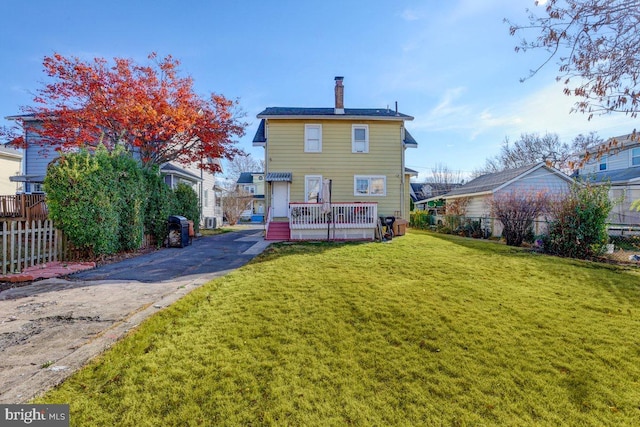 rear view of house featuring a lawn