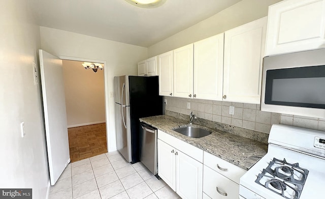 kitchen featuring light stone counters, sink, white cabinets, and stainless steel appliances