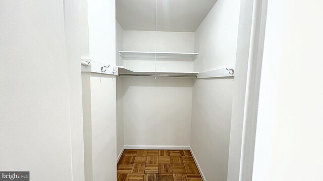 walk in closet featuring parquet floors