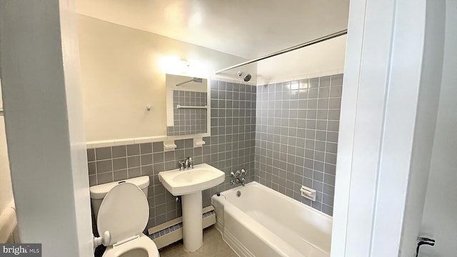 bathroom with tiled shower / bath, tile walls, and toilet