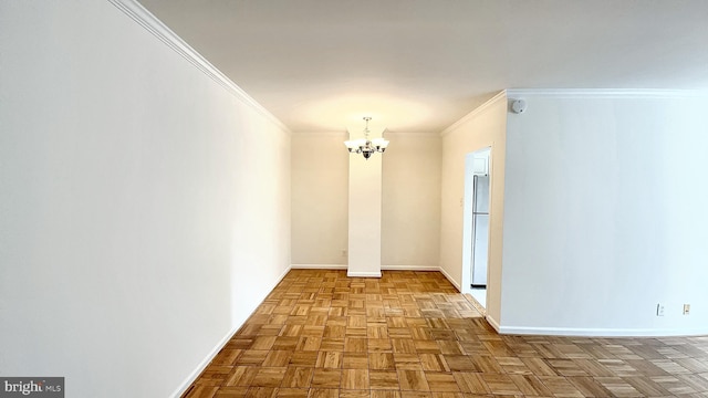 empty room featuring light parquet flooring, ornamental molding, and an inviting chandelier