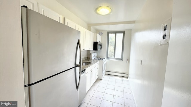 kitchen featuring light stone counters, stainless steel appliances, light tile patterned floors, a baseboard radiator, and white cabinetry