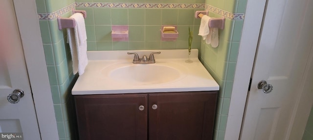 bathroom featuring vanity and tile walls