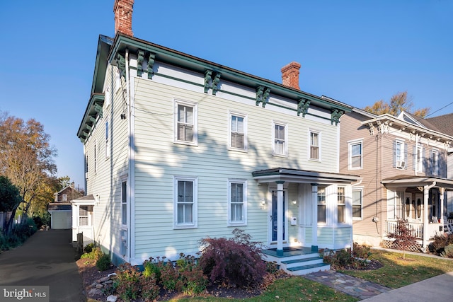 italianate home with an outdoor structure and a garage