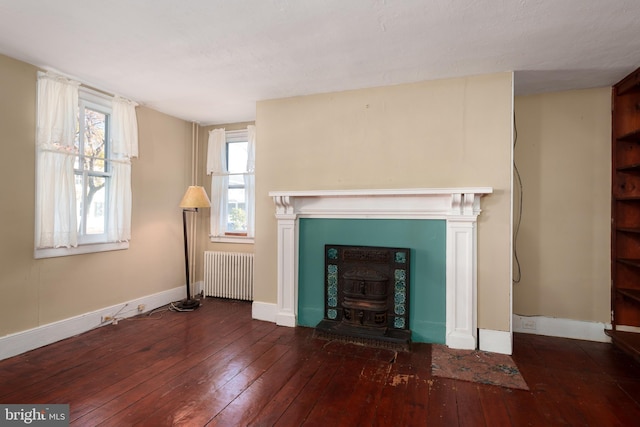 unfurnished living room featuring radiator heating unit and dark wood-type flooring