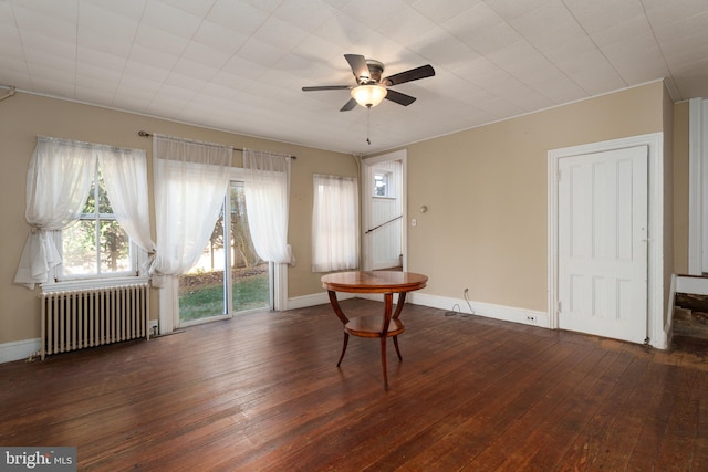 interior space featuring radiator heating unit, ceiling fan, and dark wood-type flooring