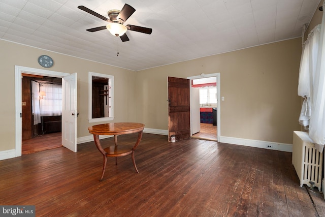 living area with radiator, dark wood-type flooring, and ceiling fan