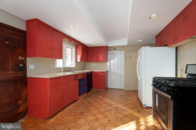 kitchen with light parquet floors, white refrigerator, sink, and stainless steel range with gas stovetop