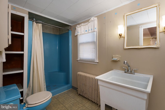 bathroom featuring toilet, walk in shower, and radiator