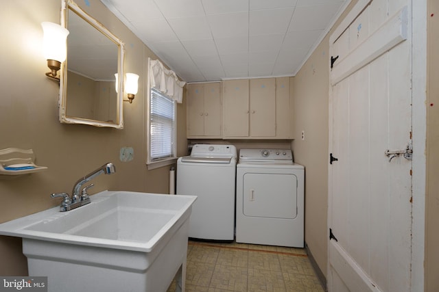 washroom featuring cabinets, separate washer and dryer, and sink