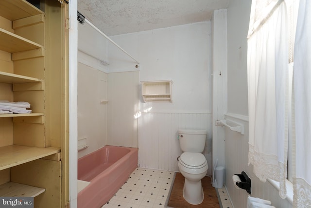 120 S Main St, Pennington, NJ 08534 - bathroom featuring a wainscoted wall, tile patterned floors, toilet, and shower / tub combination