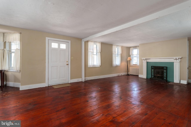 entryway with a fireplace, dark hardwood / wood-style flooring, a textured ceiling, and radiator heating unit