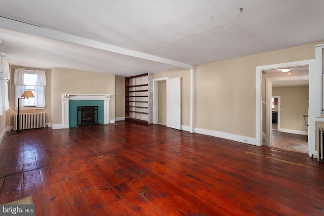 unfurnished living room with radiator heating unit and dark hardwood / wood-style floors