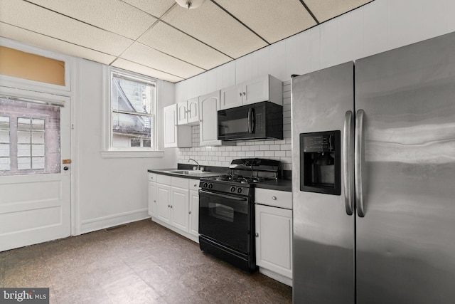 kitchen with a drop ceiling, sink, decorative backsplash, white cabinets, and black appliances