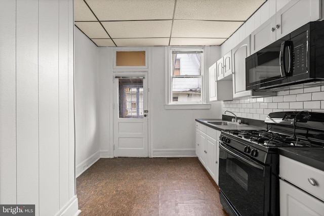 kitchen featuring decorative backsplash, a paneled ceiling, sink, black appliances, and white cabinetry