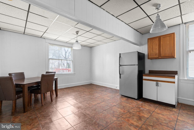 tiled dining room featuring a paneled ceiling