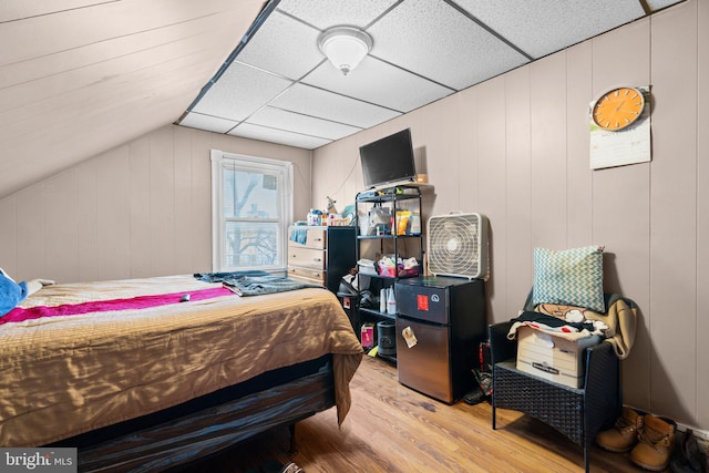 bedroom featuring light hardwood / wood-style floors and lofted ceiling