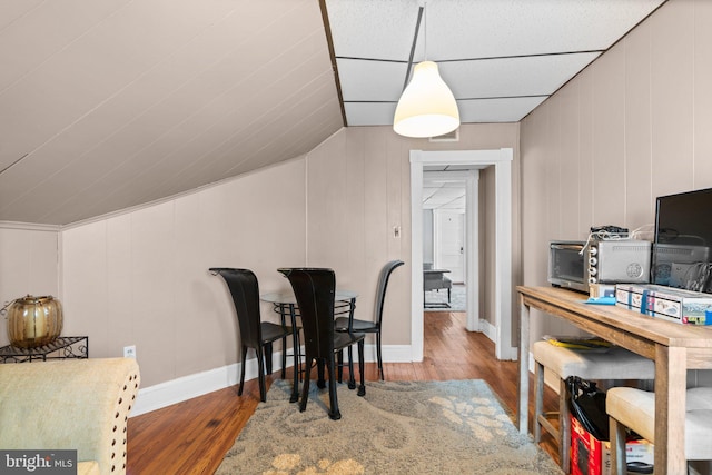 dining area featuring wood-type flooring and lofted ceiling