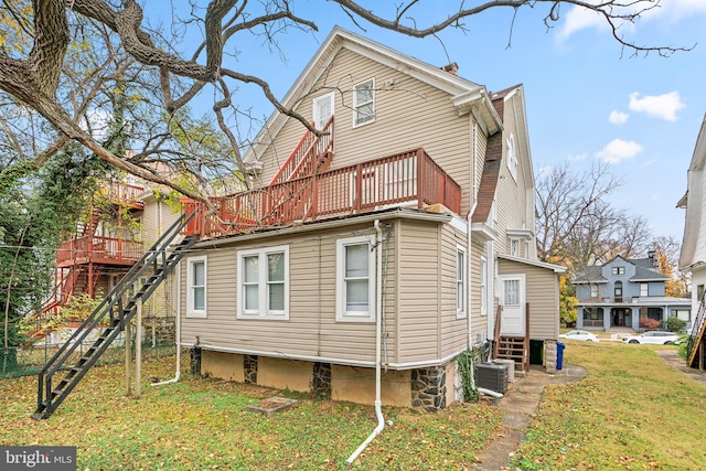 back of property featuring a yard, a balcony, and cooling unit