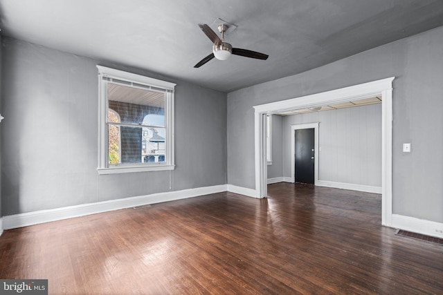 spare room featuring ceiling fan and dark wood-type flooring