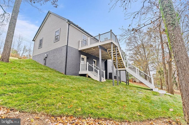 back of house featuring a wooden deck and a lawn