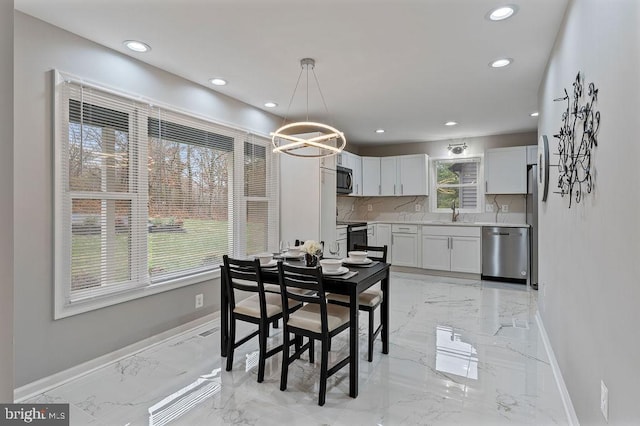 dining space with an inviting chandelier, plenty of natural light, and sink