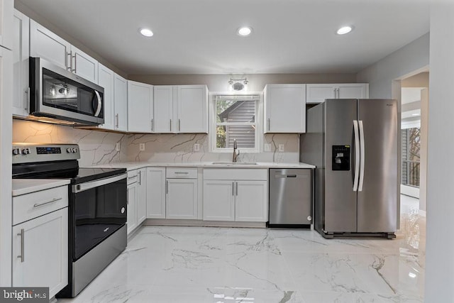 kitchen featuring decorative backsplash, white cabinetry, sink, and stainless steel appliances