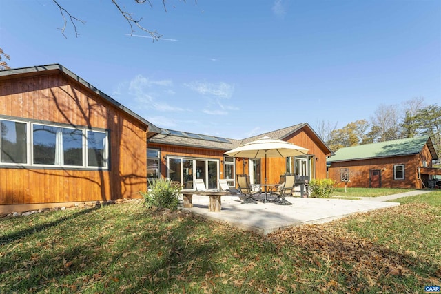 back of house featuring a patio area and a yard