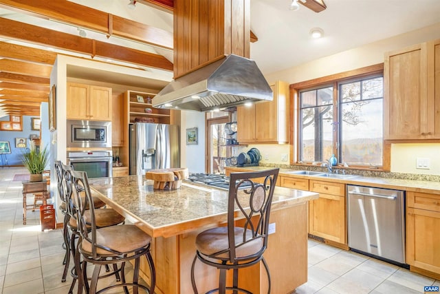 kitchen featuring a kitchen breakfast bar, a center island, stainless steel appliances, and light brown cabinets