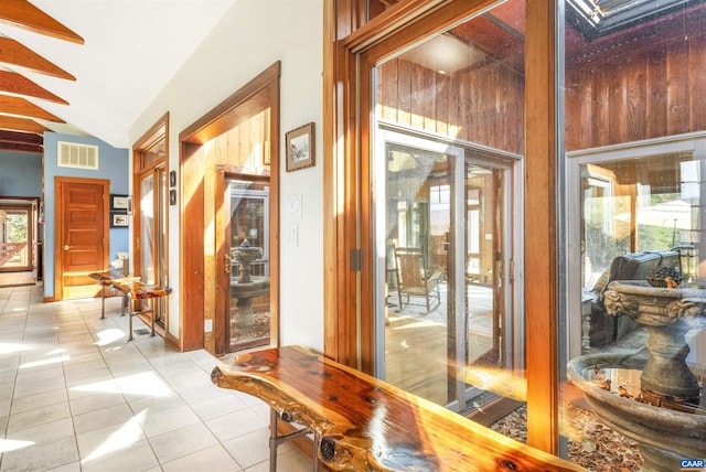 interior space with light tile patterned flooring and vaulted ceiling